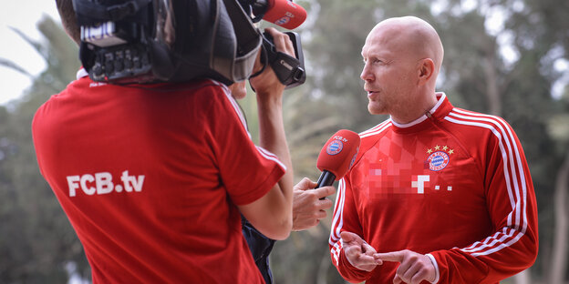 Ein Mann im FC-Bayern-Trikot wird für das fernsehen interviewt Ein Mann im FC-Bayern-Trikot wird für das fernsehen interviewt