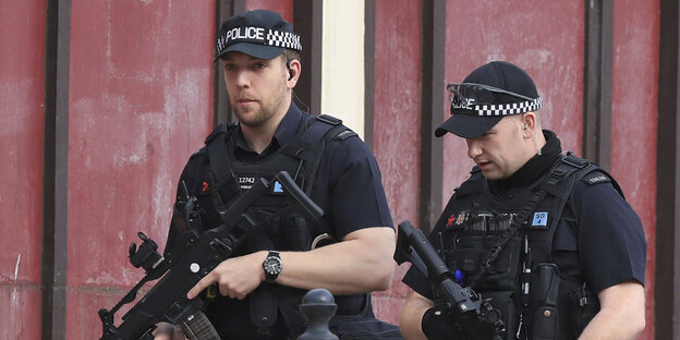 Zwei bewaffnete Polizisten patrouillern durch Manchester Zwei bewaffnete Polizisten patrouillern durch Manchester