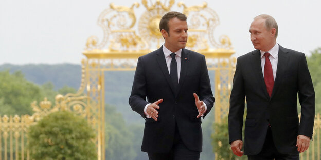 Emmanuel Macron und Vladimir Putin laufen nebeneinander Emmanuel Macron und Vladimir Putin laufen nebeneinander