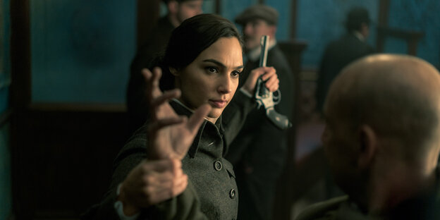Gal Gadot als Wonder Woman nimmt in einer Szene des Films einem Mann eine Pistole ab Gal Gadot als Wonder Woman nimmt in einer Szene des Films einem Mann eine Pistole ab