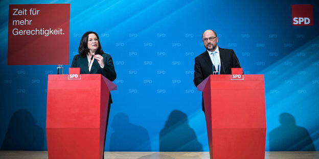 Nahles und Schulz jeweils hinter einem roten Pult vor einer blauen Wand Nahles und Schulz jeweils hinter einem roten Pult vor einer blauen Wand