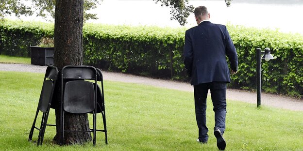 Man sieht den finnischen Ministerpräsidenten, Juha Sipilä, von hinten, wie er eine Pressekonferenz verlässt.