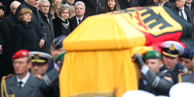 ein Sarg mit einer großen Deutschlandfahne wird von Soldaten getragen ein Sarg mit einer großen Deutschlandfahne wird von Soldaten getragen