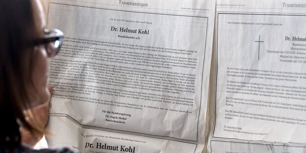 Eine Frau liest Traueranzeigen Eine Frau liest Traueranzeigen
