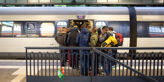 Flüchtlinge steigen in einen Zug Flüchtlinge steigen in einen Zug