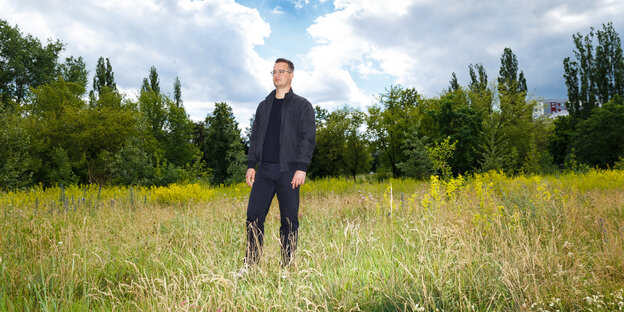 Ein Mann auf einer Wiese, unter blauem Himmel Ein Mann auf einer Wiese, unter blauem Himmel
