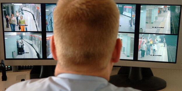 Ein Mann beobachtet Bildschirme, die Videoüberwachungsaufnahmen der Ubahn zeigen Ein Mann beobachtet Bildschirme, die Videoüberwachungsaufnahmen der Ubahn zeigen