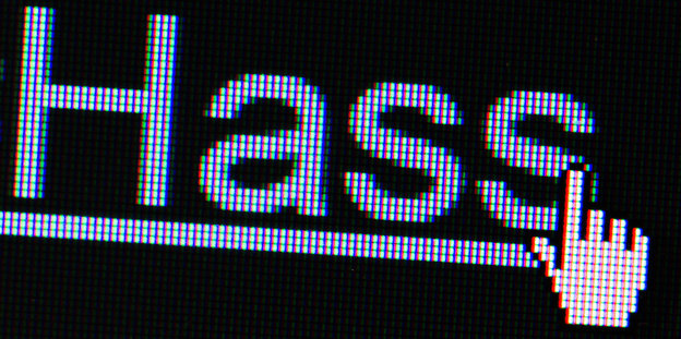 Ein Handsymbol befindet sich auf einem Computerbildschirm vor dem Wort Hass