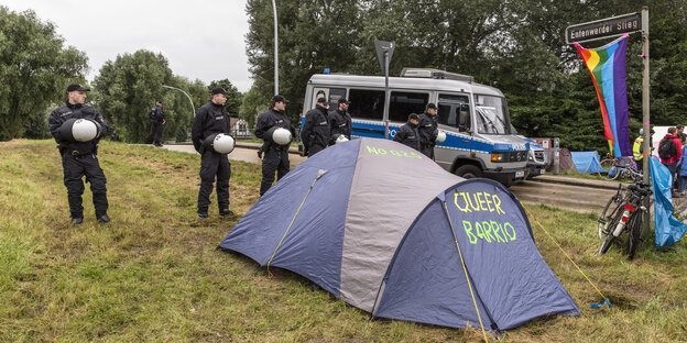Polizisten haben ein Zelt umstellt Polizisten haben ein Zelt umstellt