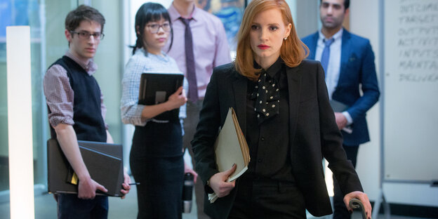 Jessica Chastain läuft durch einen Flur, hinter ihr stehen Menschen Jessica Chastain läuft durch einen Flur, hinter ihr stehen Menschen