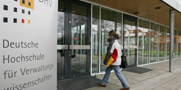 Eine Frau geht in ein Gebäude Eine Frau geht in ein Gebäude