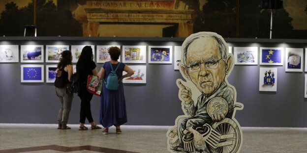 Eine Karikatur des deutschen Finanzministers Wolfgang Schäuble mit einer griechischen Drachme-Münze in einer Ausstellung in Athen Eine Karikatur des deutschen Finanzministers Wolfgang Schäuble mit einer griechischen Drachme-Münze in einer Ausstellung in Athen