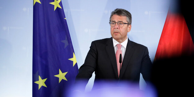 Ein Mann spricht und hebt seinen rechten Zeigefinger Ein Mann spricht und hebt seinen rechten Zeigefinger