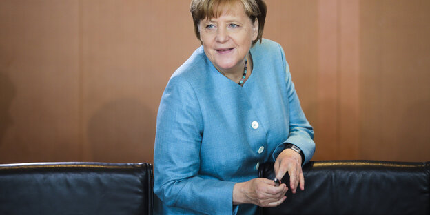 Angela Merkel, eine Frau mit kurzen Haaren in einem blauen Anzug Angela Merkel, eine Frau mit kurzen Haaren in einem blauen Anzug