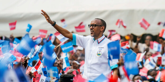Ruandas Präsident Paul Kagame winkt Menschen mit Fähnchen zu Ruandas Präsident Paul Kagame winkt Menschen mit Fähnchen zu