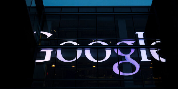Ein dunkles Gebäude mit hell leuchtendem Google-Schriftzug Ein dunkles Gebäude mit hell leuchtendem Google-Schriftzug