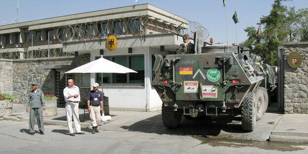 Ein gepanzertes Fahrzeug fährt auf das Gelände der deutschen Botschaft in Kabul, Afghanistan. Einige Menschen stehen vor dem Gelände Ein gepanzertes Fahrzeug fährt auf das Gelände der deutschen Botschaft in Kabul, Afghanistan. Einige Menschen stehen vor dem Gelände