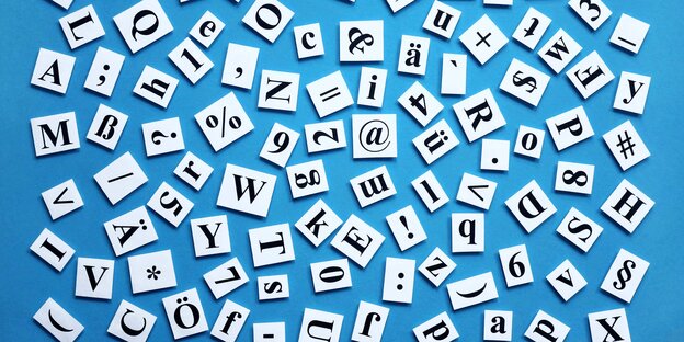 Viele Buchstaben, Zahlen und Zeichen einer Tastatur liegen durcheinander gewürfelt auf einer blauen Unterlage Viele Buchstaben, Zahlen und Zeichen einer Tastatur liegen durcheinander gewürfelt auf einer blauen Unterlage