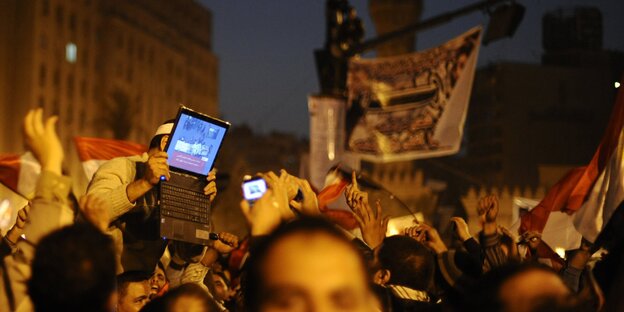 Protestierende auf den Tahir-Platz in Kairo halten einen Laptop in die Höhe Protestierende auf den Tahir-Platz in Kairo halten einen Laptop in die Höhe