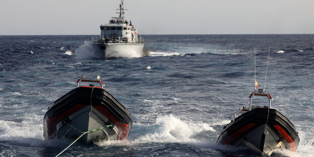 Ein Boot fährt auf dem Meer zwei kleineren Schlauchbooten hinterher Ein Boot fährt auf dem Meer zwei kleineren Schlauchbooten hinterher