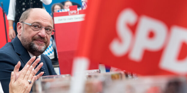 Ein Mann schaut ernst, daneben SPD-Flagge Ein Mann schaut ernst, daneben SPD-Flagge