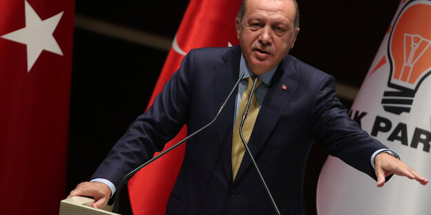 Erdogan steht am Rednerpult und streckt den Arm aus Erdogan steht am Rednerpult und streckt den Arm aus