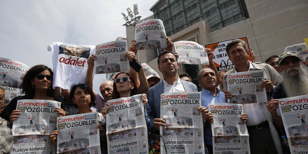 Journalisten und Aktivisten halten vor dem Gericht in Istanbul Ausgaben der "Cumhuriyet" hoch Journalisten und Aktivisten halten vor dem Gericht in Istanbul Ausgaben der "Cumhuriyet" hoch
