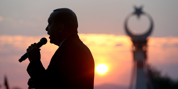 Schatten von Recep Tayyip Erdogan mit Mikrofon vor Sonnenuntergang Schatten von Recep Tayyip Erdogan mit Mikrofon vor Sonnenuntergang