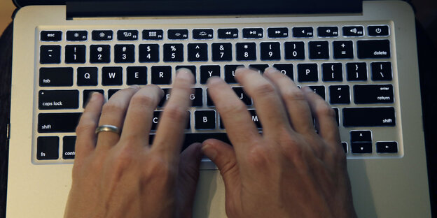 Zwei Hände tippen auf einer Laptoptastatur Zwei Hände tippen auf einer Laptoptastatur