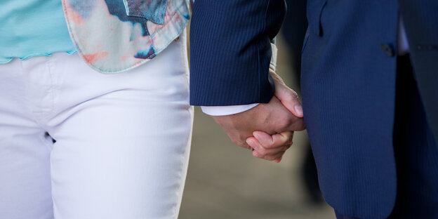 Zwei Menschen gehen Hand in Hand Zwei Menschen gehen Hand in Hand