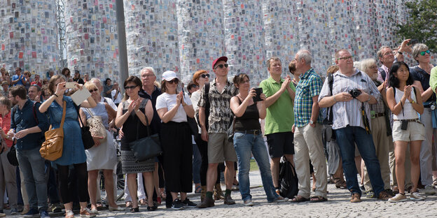 Menschen stehen in einer Reihe und machen Fotos Menschen stehen in einer Reihe und machen Fotos