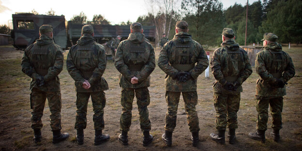 Sechs Männer in Uniform stehen nebeneinander