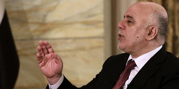 Haidar al-Abadi gestikuliert, im Hintergrund eine irakische Flagge Haidar al-Abadi gestikuliert, im Hintergrund eine irakische Flagge