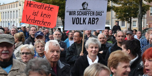 Menschen auf einer Demonstration halten Schilder hoch Menschen auf einer Demonstration halten Schilder hoch