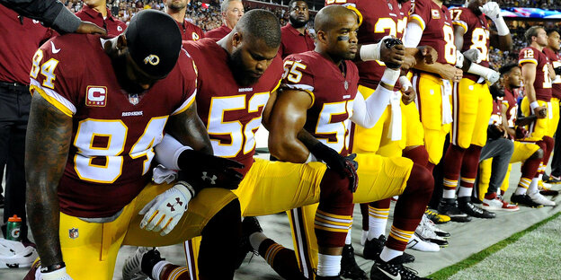 Spieler der Washington Redskins knien nieder vor dem Spiel gegen die Oakland Raiders Spieler der Washington Redskins knien nieder vor dem Spiel gegen die Oakland Raiders