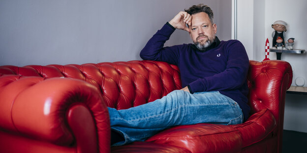 Ein Mann sitzt auf einer Couch Ein Mann sitzt auf einer Couch