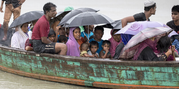 Rohingya, die dicht gedrängt in einem Boot sitzen Rohingya, die dicht gedrängt in einem Boot sitzen