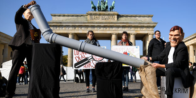 Zwei Menschen mit Putin und Schröder Maske demonstrieren vor dem Brandenburger Tor Zwei Menschen mit Putin und Schröder Maske demonstrieren vor dem Brandenburger Tor