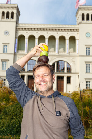 Robert Habeck stapelt Avocado, Zitrone und Apfel auf seinem Kopf Robert Habeck stapelt Avocado, Zitrone und Apfel auf seinem Kopf