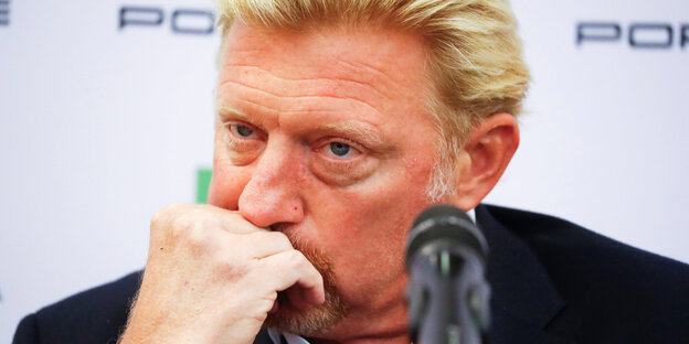 Mann mit blonden Haaren guckt zerknautscht und stützt sich auf seine Faust - es ist Boris Becker Mann mit blonden Haaren guckt zerknautscht und stützt sich auf seine Faust - es ist Boris Becker