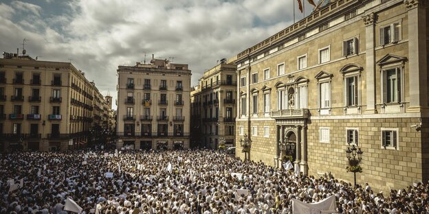 Ein Platz in Barcelona ist voller Menschen, die komplett weiß gekleidet sind Ein Platz in Barcelona ist voller Menschen, die komplett weiß gekleidet sind