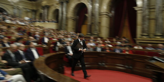 Carles Puigdemont läuft über einen roten Teppich im Parlament in Barcelona Carles Puigdemont läuft über einen roten Teppich im Parlament in Barcelona