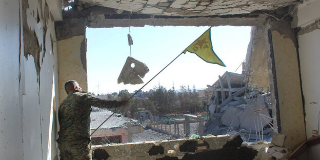 ein Sodat mit einer Fahne in der Hand in einem völlig ausgebombten Haus ein Sodat mit einer Fahne in der Hand in einem völlig ausgebombten Haus