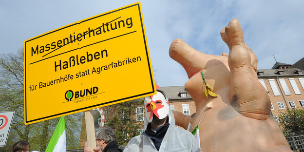 ein als Hunn verkleideter Mensch nebem einem aufblasbaren Schwein ein als Hunn verkleideter Mensch nebem einem aufblasbaren Schwein