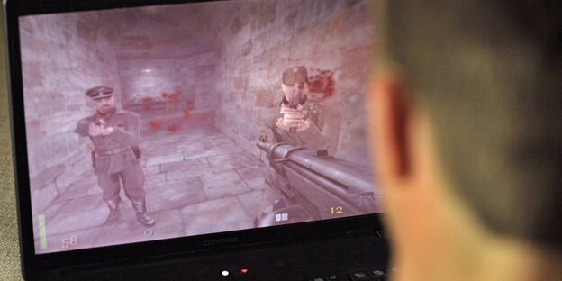 Ein Jugendlicher schaut auf einen Laptopbildschirm Ein Jugendlicher schaut auf einen Laptopbildschirm