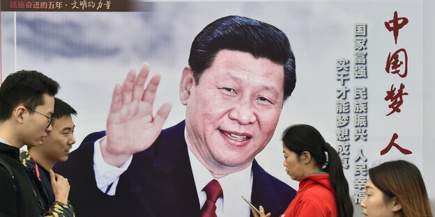 Passanten gehen in Peking an einem Plakat vorbei, das den winkenden chinesischen Präsidenten Xi zeigt Passanten gehen in Peking an einem Plakat vorbei, das den winkenden chinesischen Präsidenten Xi zeigt