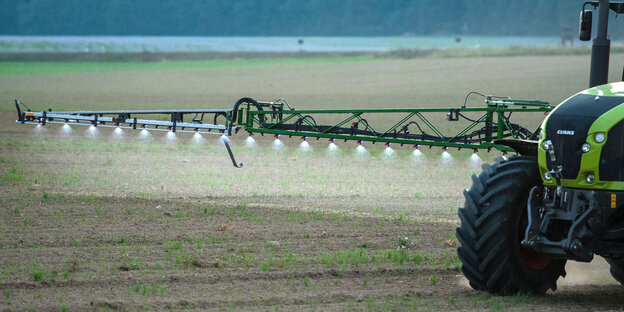 Ein Traktor mit einer Düngerspritze Ein Traktor mit einer Düngerspritze