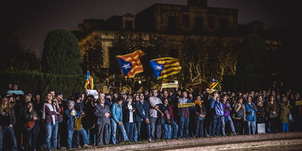 Demonstranten stehen bei Nacht mit Fahnen vor dem katalanischen Parlament in Barcelona Demonstranten stehen bei Nacht mit Fahnen vor dem katalanischen Parlament in Barcelona