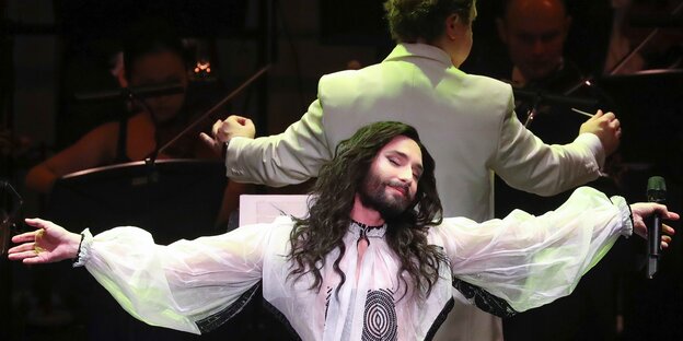 Conchita auf der Bühne mit Orchester im Hintergrund Conchita auf der Bühne mit Orchester im Hintergrund