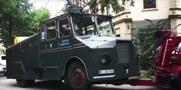 ein grüner Wasserwerfer wird abgeschleppt